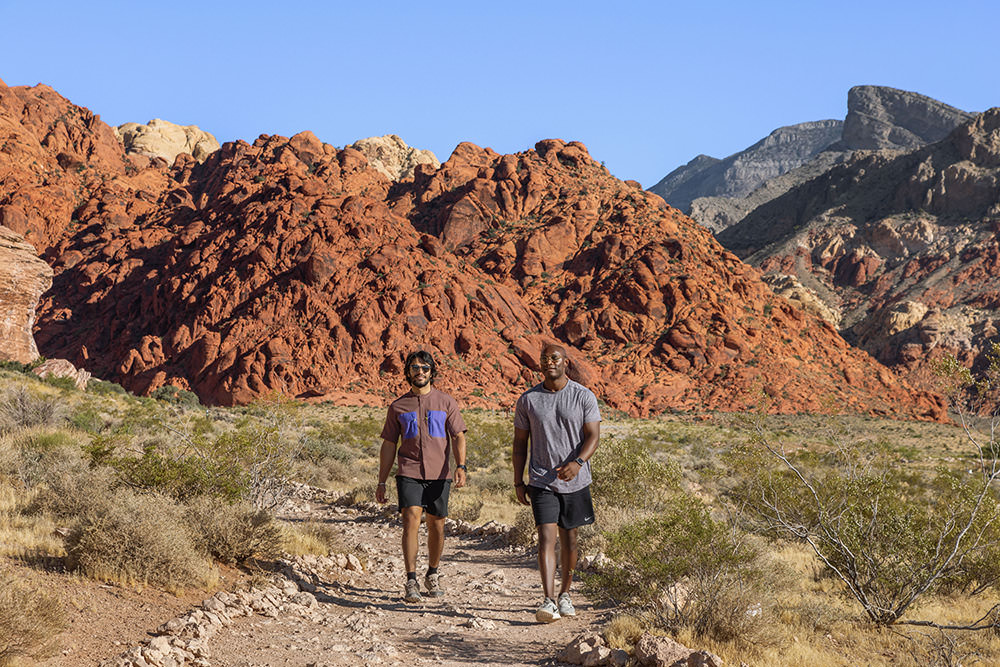 people walking an outdoor trail near the mountains